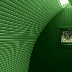 A green light shining inside a timber pod