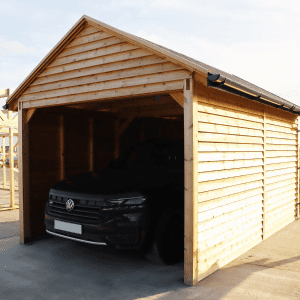 Timber garage housing a black car